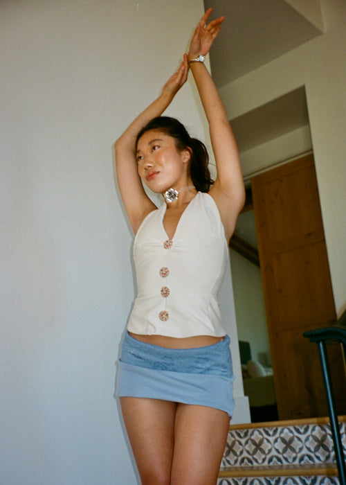 Woman wearing The Tresaire Classic Mini in dusty blue with lace waistband overlay paired with the tresaire halter